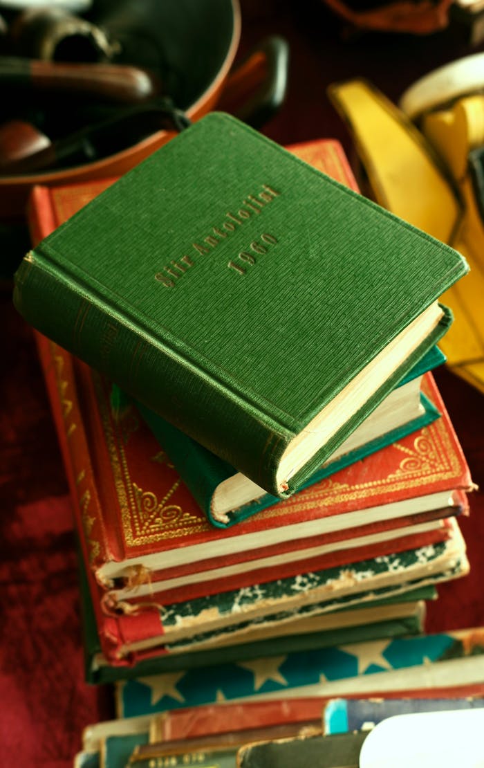Vertical shot of a stack of colorful vintage books focusing on a green one.